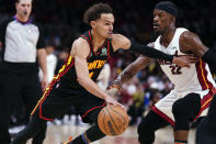 Atlanta Hawks guard Trae Young, front left, drives against Miami Heat forward Jimmy Butler (22) in the first half of an NBA playoff basketball game Sunday, April 24, 2022, in Atlanta. (AP Photo/John Bazemore)