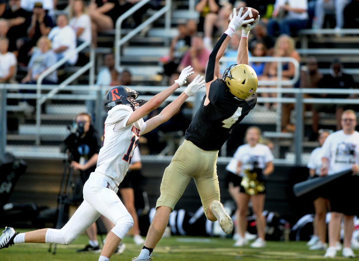 Sacred Heart-Griffin's Jake Hamilton catches a pass while being guarded by Rochester's Camron Beal during the game at SHG Friday August 26, 2022. The pass set up a touchdown run the nest play.