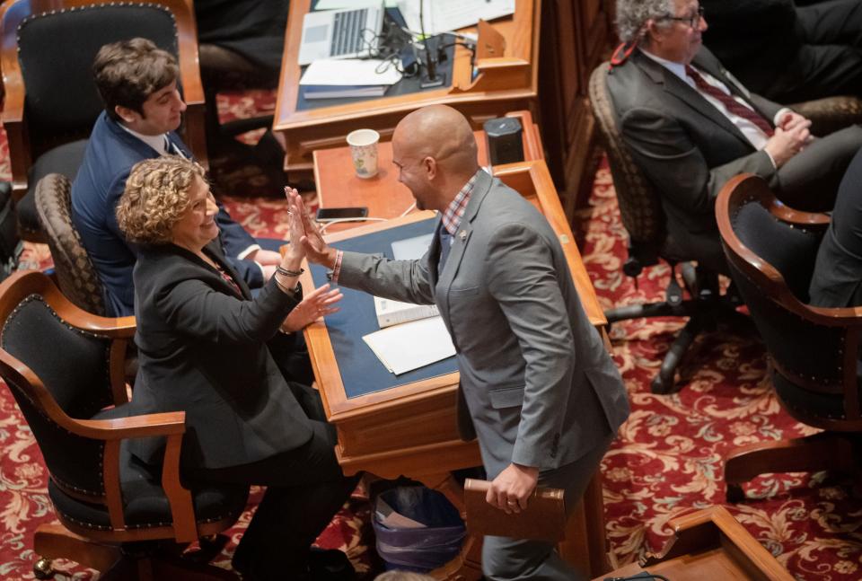 Sen. Claire Celsi high-fives freshman Sen. Izaah Knox after his swearing in on the first day of the legislative session, Monday, Jan. 9, 2023.
