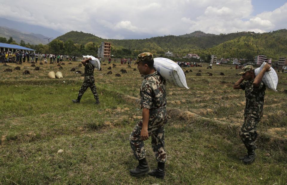 Nepalese soldiers unload relief material brought in an Indian air force helicopter for victims of Saturday's earthquake at Trishuli Bazar in Nepal, Monday, April 27, 2015.   (AP Photo/Altaf Qadri)
