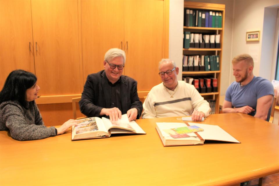 Gail Rosenthal (from left), director, Sara & Sam Schoffer Holocaust Resource Center, Stockton University, Michael Hayse, Associate Professor of History, Stockton University, John Dominy of Lanoka Harbor and grandfather of Michael Ofsanko, and Ofsanko, student at Stockton University, look at Dominy’s photo album from his 1999 trip to Israel on a Stockton University Study Tour.