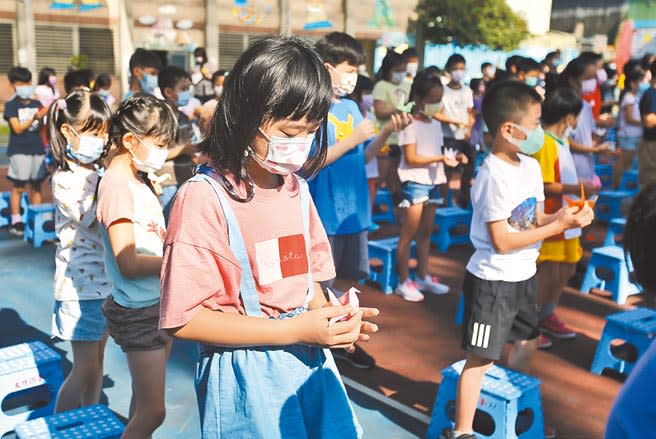 學生們1日終於開學上課了，台北市大佳國小在朝會時發放老師們在暑假期間折的紙鶴，讓二至六年級的師生一起為全世界的疫情祈福。（杜宜諳攝）