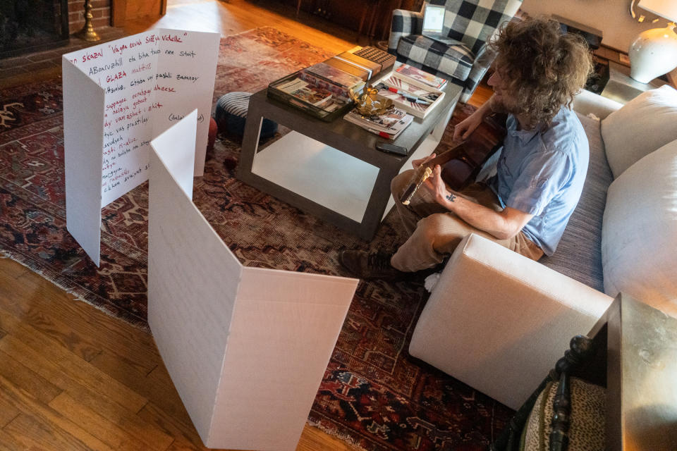 Stokes sits in his living room in front of the Russian text of “The General” – Photo credit: Bryan Lasky for Rolling Stone