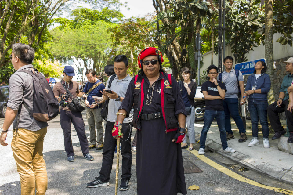 A picture of Malaysian media star, Rani Kulup, surrounded by people standing on a road.