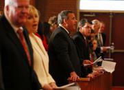 Governor Chris Christie along with Lt. Governor Kim Guadagno (2nd L) and her husband Michael (L) attend an inauguration service in Newark, New Jersey, January 21, 2014. Christie, a Republican Party star enmeshed in scandal after re-election in November, will return to the themes of small government and bipartisan cooperation when he is sworn in for a second term on Tuesday. Excerpts from Christie's inaugural address provided by the governor's office made no mention of the abuse of power accusations swirling around some of his closest aides. Instead, the speech criticized the idea that an "almighty government" can "fix any problem." (REUTERS/Adam Hunger)