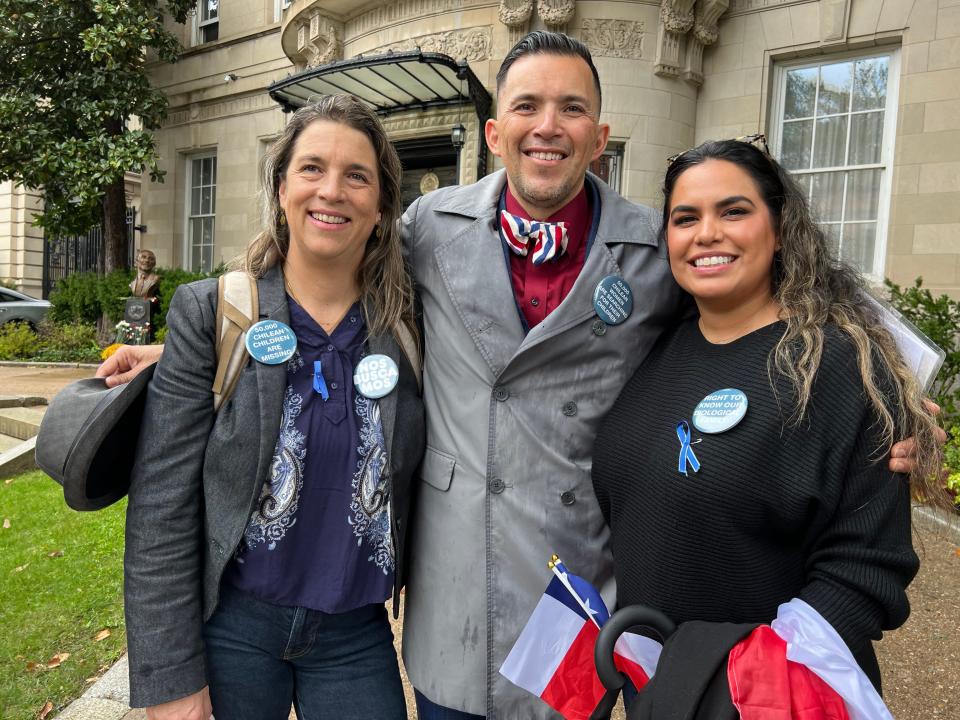 (From left to right) Constanza del Río, founder and president of the Nos Buscamos nonprofit, smiles in front of the Chilean embassy in Washington, D.C. alongside two of Chile's stolen children, Jimmy Lippert Thyden of Ashburn, Virginia, and Adrian Reamey of Los Angeles.