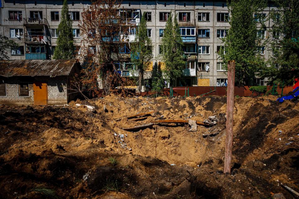 A photograph shows a damaged residenial buildin and crater, after missile strikes in Chasiv Yar near the frontline city of Bakhmut, Donetsk region (AFP via Getty Images)