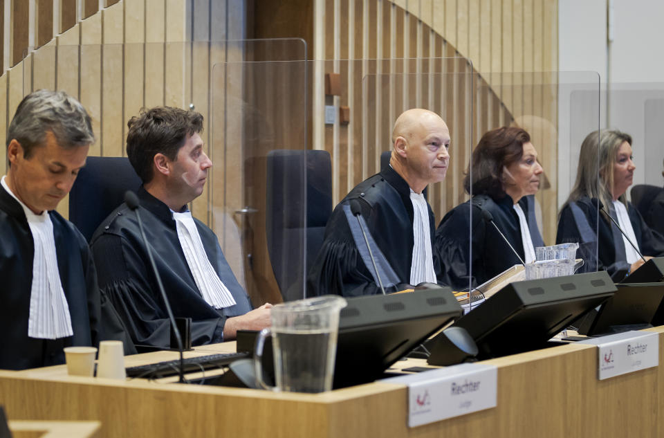 Presiding judge Hendrik Steenhuis, center, opens the court session as the trial resumed at the high security court building at Schiphol Airport, near Amsterdam, Monday, June 8, 2020, for three Russians and a Ukrainian charged with crimes including murder for their alleged roles in the shooting down of Malaysia Airlines Flight MH17 over eastern Ukraine nearly six years ago. (AP Photo/Robin van Lonkhuijsen, POOL)