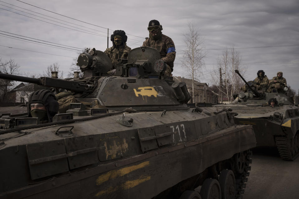 Ukrainian servicemen ride atop tanks in the town of Trostsyanets, Ukraine, Monday, March 28, 2022. Trostsyanets was recently retaken by Ukrainian forces after being held by Russians since the early days of the war. (AP Photo/Felipe Dana)