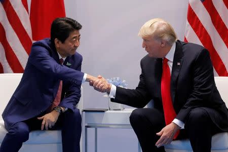 FILE PHOTO: Japanese Prime Minister Shinzo Abe shakes hands with U.S. President Donald Trump during the bilateral meeting at the G20 leaders summit in Hamburg, Germany July 8, 2017. REUTERS/Carlos Barria