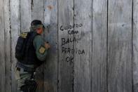 An agent of the Brazilian Institute for the Environment and Renewable Natural Resources, or Ibama, takes part in operation "Operation Green Wave" in Apui, in the southern region of the state of Amazonas, Brazil, July 26, 2017. The sign reads: "Careful with stray bullets." REUTERS/Bruno Kelly