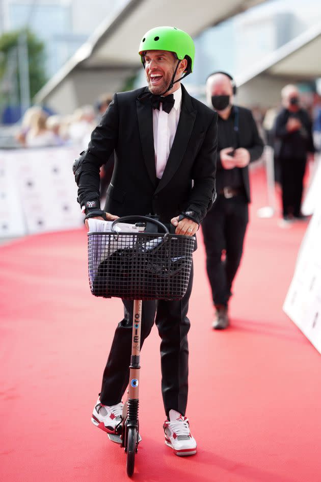 Joel looked somewhat more comfortable on the scooter as he made it further down the red carpet (Photo: Scott Garfitt/Shutterstock)