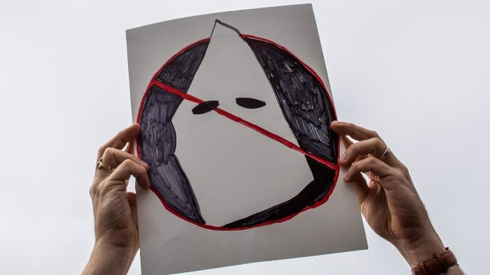 Joe Cook Gines holds an anti-Ku Klux Klan placard at Huntington Beach pier during an April protest against white supremacy in Huntington Beach, California. (Photo by Apu Gomes/Getty Images)