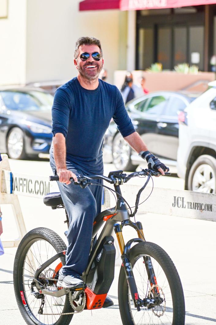 Fearless Simon Cowell hops back on a bike while still wearing a hand brace from a biking accident to film scenes for America apos s Go Talent