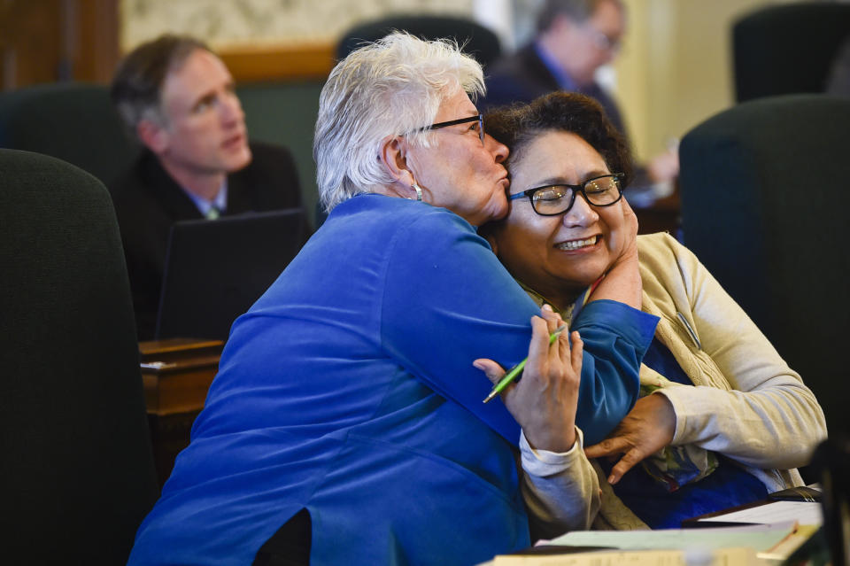 This April 15, 2019 photo, Democratic Sen. Diane Sands of Missoula and Democratic Sen. Susan Webber of Browning celebrate on the Senate floor in Helena, Montana, after the Senate endorsed on second reading a bill to allow the state Department of Justice to assist with the investigation of all missing persons cases. The act was named in memory of woman who was killed on the Northern Cheyenne Reservation in 2013. Webber says the 2021 legislative session is difficult with a bill to end same-day voter registration moving forward along with an attempt to cut funding for two health department positions dedicated to Native American communities. (Thom Bridge/Independent Record via AP)