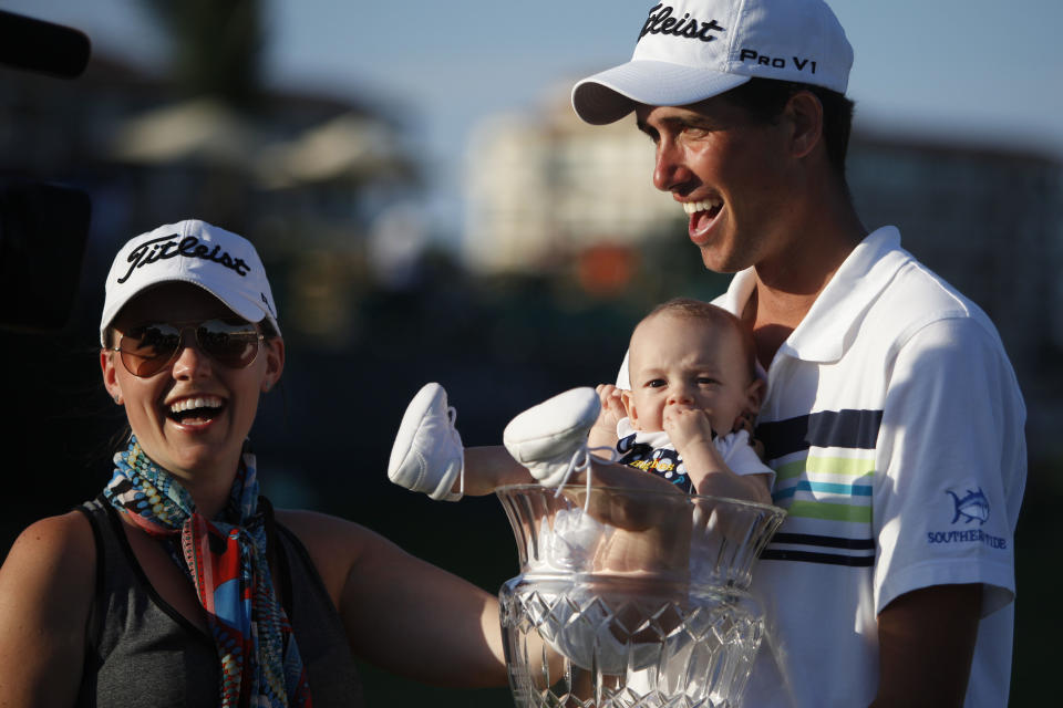 U.S.’ Chesson Hadley celebrates with his wife Amanda and his newborn son Hughes, who sits in his trophy, after winning the Puerto Rico Open PGA golf tournament in Rio Grande, Puerto Rico, Sunday, March 9, 2014. (AP Photo/Ricardo Arduengo)