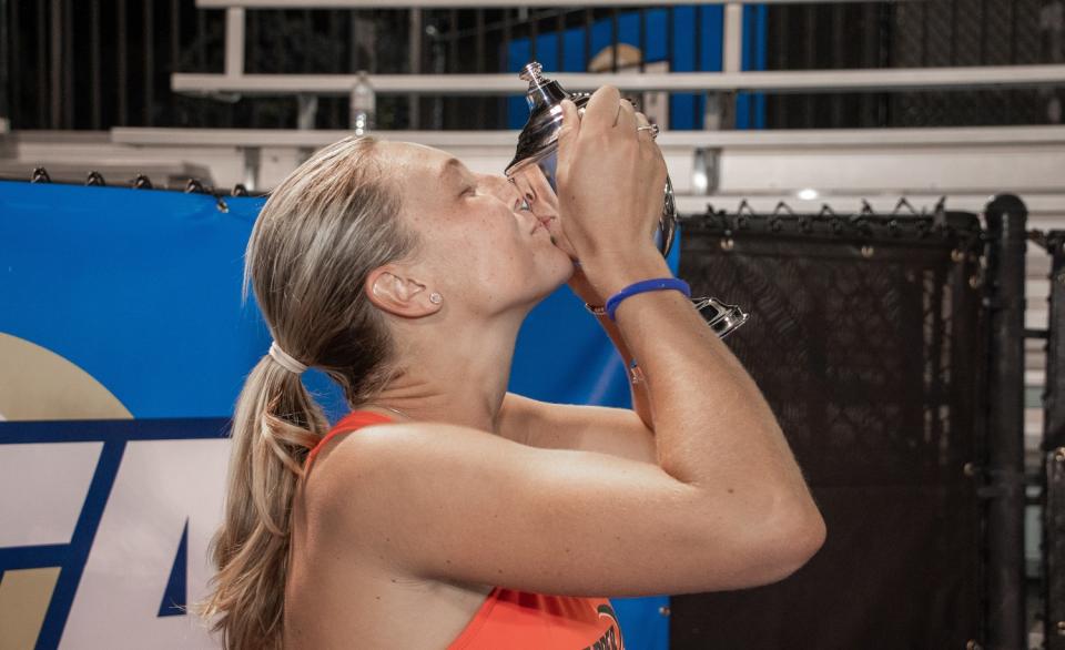 Pepperdine tennis player Ashley Lahey kisses a trophy.