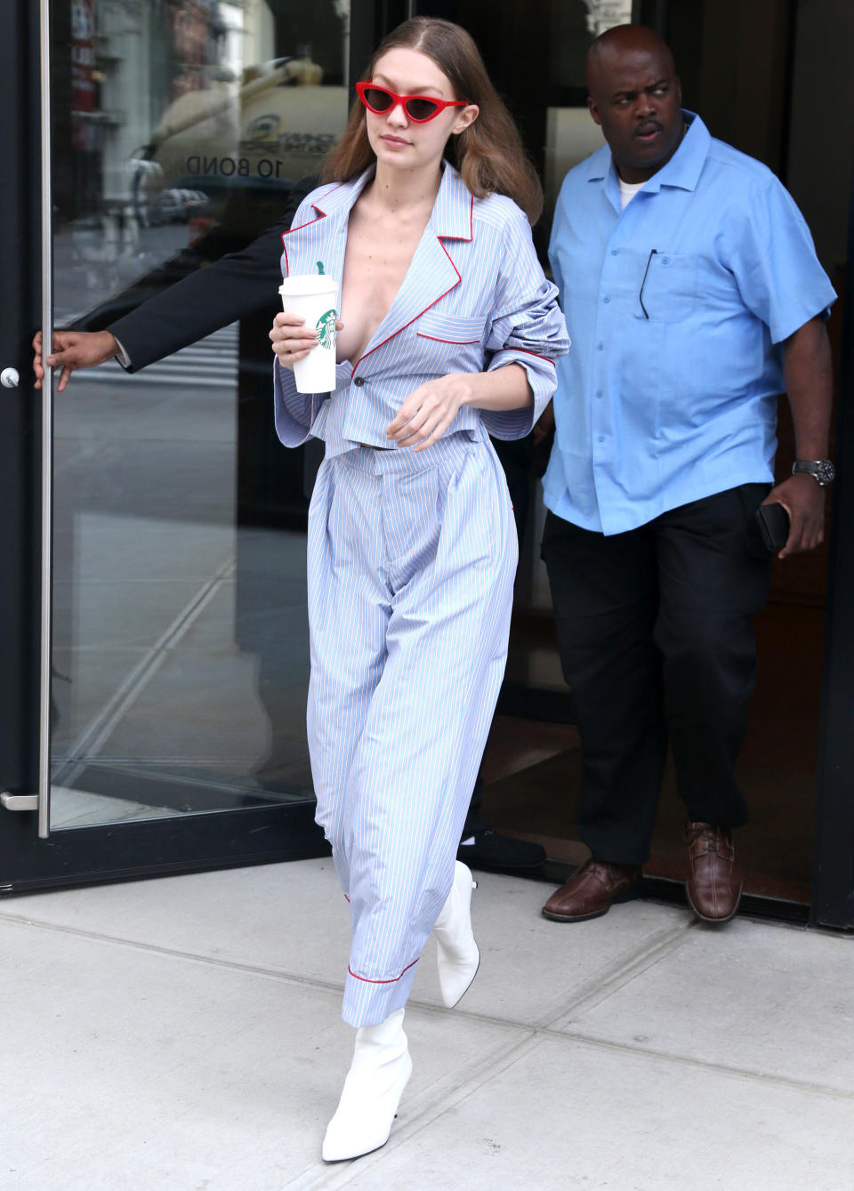 Hadid accessorized with red sunglasses and Starbucks. (Photo: Splash News)