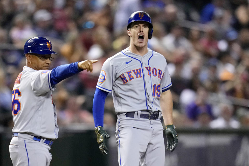 New York Mets' Mark Canha (19) celebrates his RBI triple against the Arizona Diamondbacks, while third base coach Joey Cora points to the right side of the infield during the ninth inning of a baseball game Wednesday, July 5, 2023, in Phoenix. (AP Photo/Ross D. Franklin)