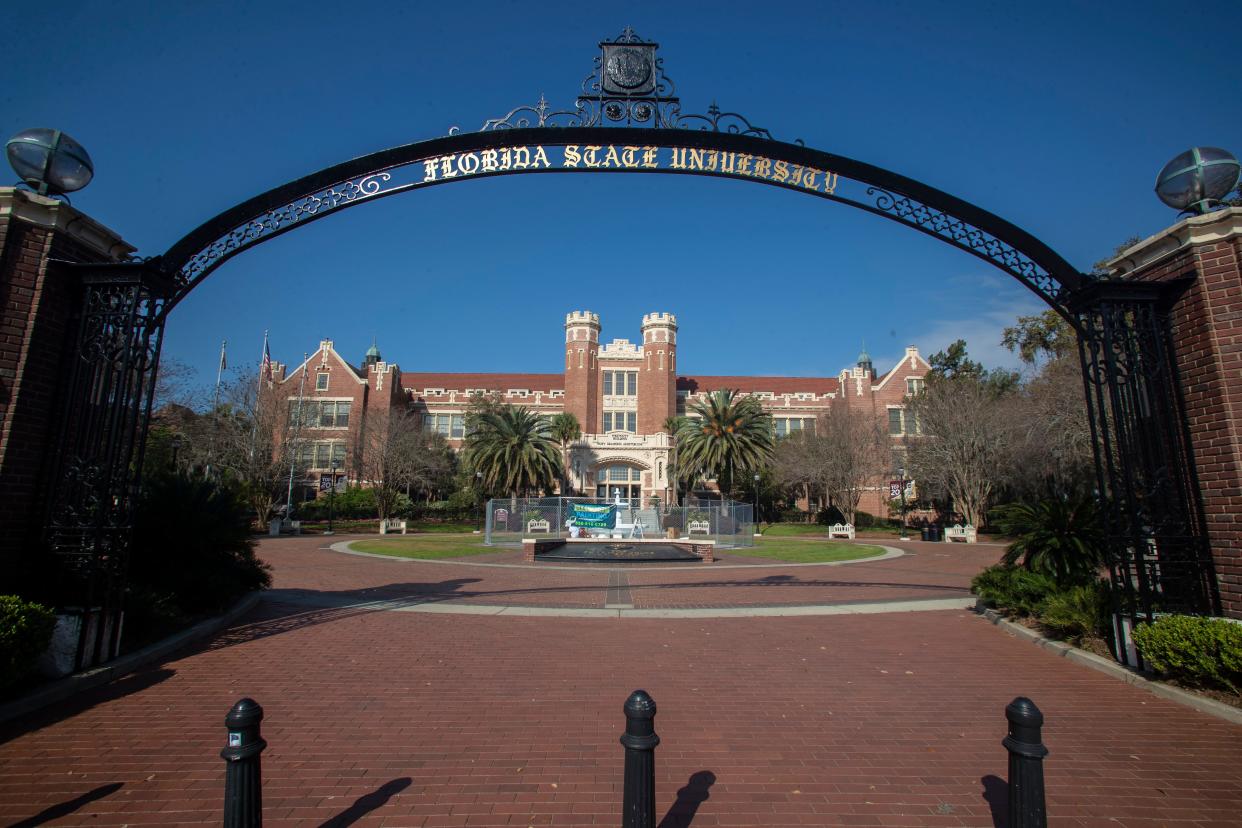 Painters placed a fence surrounding the Westcott fountain on Florida State University's campus, as they repaint the fountain, Wednesday, March 18, 2020. 