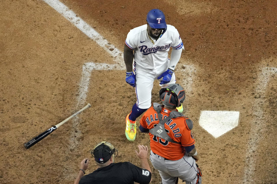 Texas Rangers' Adolis Garcia, top, confronts Houston Astros catcher Martin Maldonado (15) after being hit by a pitch during the eighth inning in Game 5 of the baseball American League Championship Series Friday, Oct. 20, 2023, in Arlington, Texas. (AP Photo/Godofredo A. Vásquez)