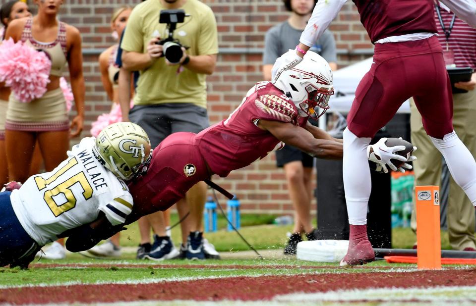 Oct 29, 2022; Tallahassee, Florida, USA; Florida State Seminoles running back Lawrance Toafili (9) reaches for the pylon as Georgia Tech Yellow Jackets defensive back K.J. Wallace (16) tackles during the first half at Doak S. Campbell Stadium. Mandatory Credit: Melina Myers-USA TODAY Sports