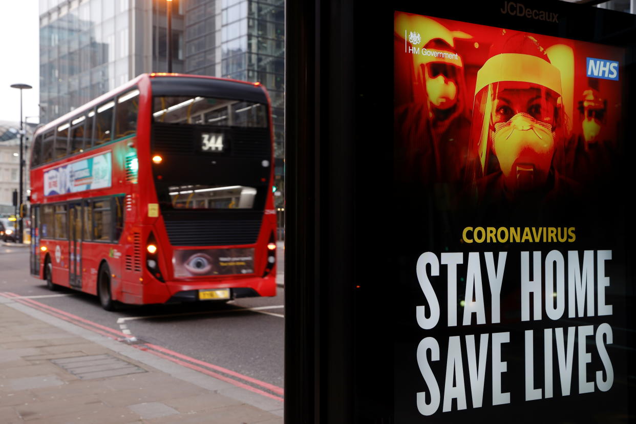 A bus drives past a government sign about the pandemic London. Photo: John Sibley/Reuters