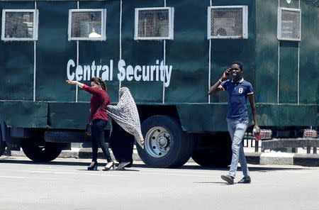 People walk in front of Egyptian riot police are seen outside El Sadat metro station at Tahrir square in center of Cairo, Egypt May 13, 2018. REUTERS/Amr Abdallah Dalsh