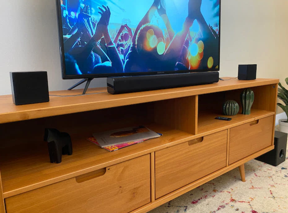 three-piece home speaker set sitting atop TV console