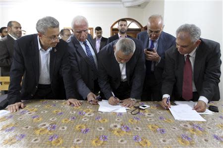 Head of the Hamas government Ismail Haniyeh (C) and senior Fatah official Azzam Al-Ahmed (2nd L) sign a reconciliation agreement in Gaza City April 23, 2014. REUTERS/Ahmed Sha'at/Gaza Prime Minister Office (PMO)/Handout via Reuters