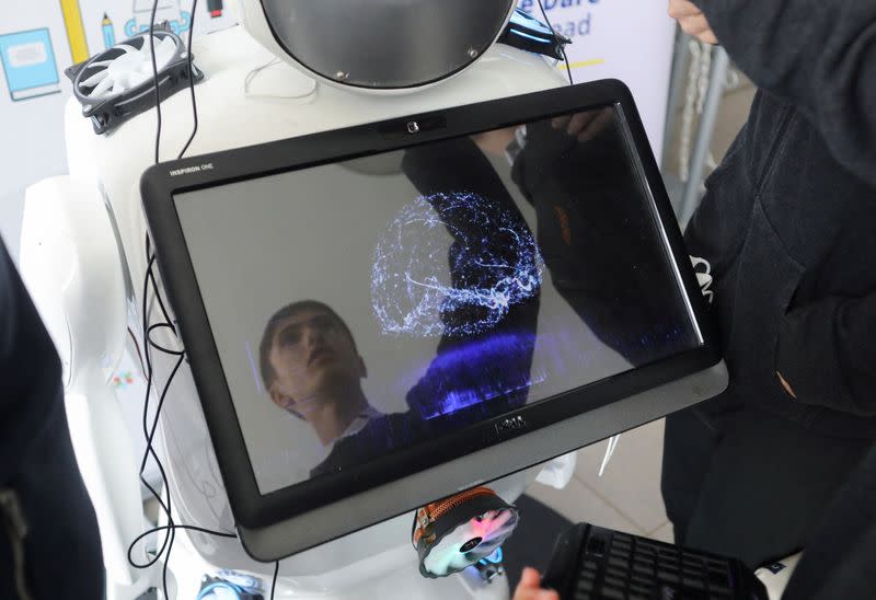 High school student Richard Erkhov is reflected on a screen of "Alnstein", a robot powered with ChatGPT, in Pascal school in Nicosia