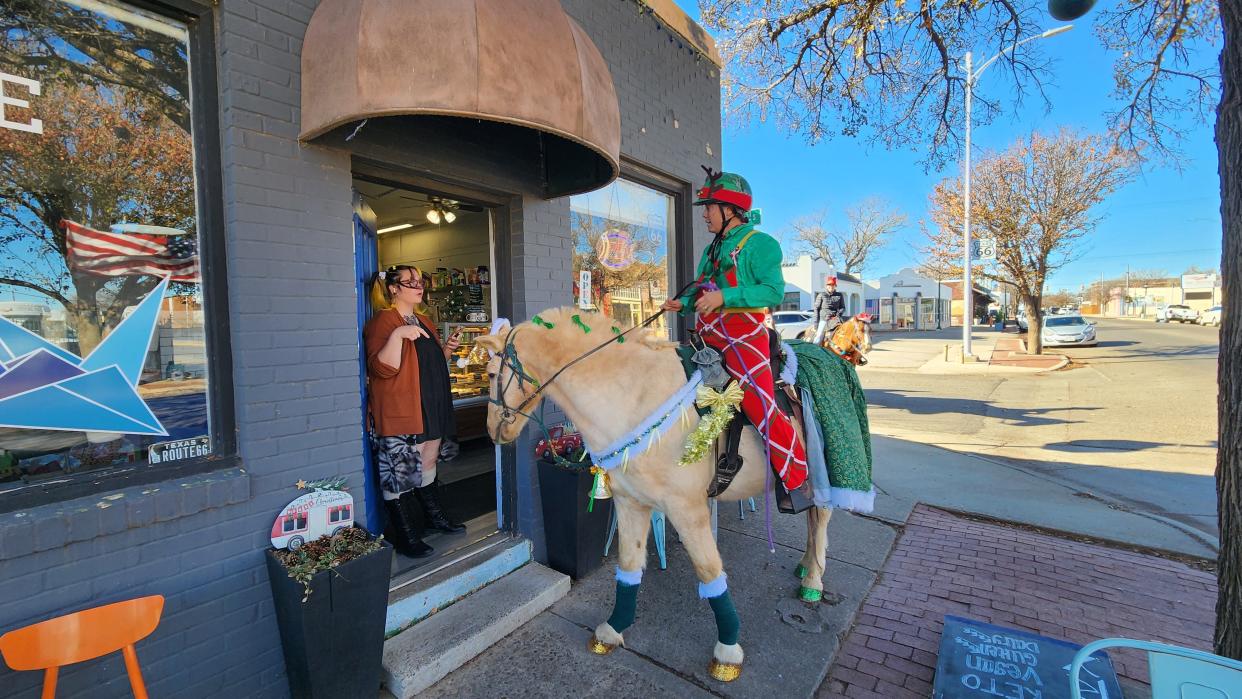 A store owner interacts with a member of the Panhandle Trail Riders Saturday morning in the historic Route 66 Amarillo District.