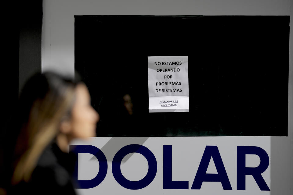 A sign that reads in Spanish "We are not operating due to system problems, sorry for the inconvenience" hangs at a money exchange shop in Buenos Aires, Argentina, Monday, Aug. 14, 2023. The Argentine peso plunged Monday after an anti-establishment candidate came first in Sunday's primary elections that will help determine the country's next president. (AP Photo/Natacha Pisarenko)