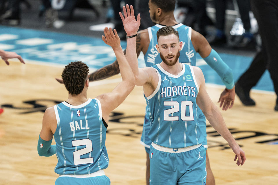 Charlotte Hornets forward Gordon Hayward (20) congratulates guard LaMelo Ball (2) who made a three-point basket against the Washington Wizards during the first half of an NBA basketball game in Charlotte, N.C., Sunday, Feb. 7, 2021. (AP Photo/Jacob Kupferman)