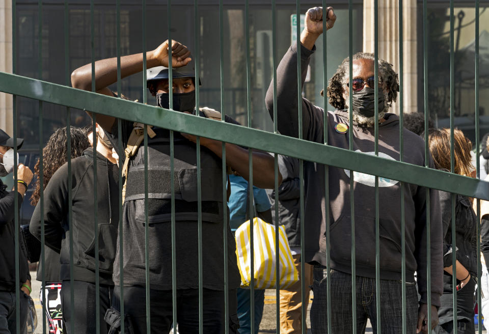 Activists protest outside the closed front gates of Downtown Women's Center in Los Angeles, Thursday, Feb. 4, 2021. U.S. District Judge David Carter held a court hearing after demanding city officials to meet with him at a Skid Row shelter to discuss how to address the worsening crisis of people living on the streets. Carter noted that 1,383 homeless people died in the city and county of Los Angeles last year, a 32% increase from 2019. (AP Photo/Damian Dovarganes)