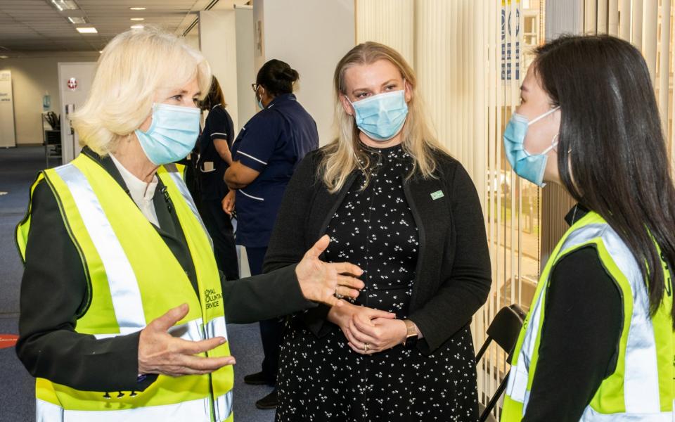 LONDON, ENGLAND - FEBRUARY 23: Camilla, Duchess of Cornwall, Royal Voluntary Service President, speaks to Liyann Ooi, a NHS Volunteer Responder Steward at Wembley Vaccination Centre on February 23, 2021 in London, England.  - Philip Hartley/Getty Images