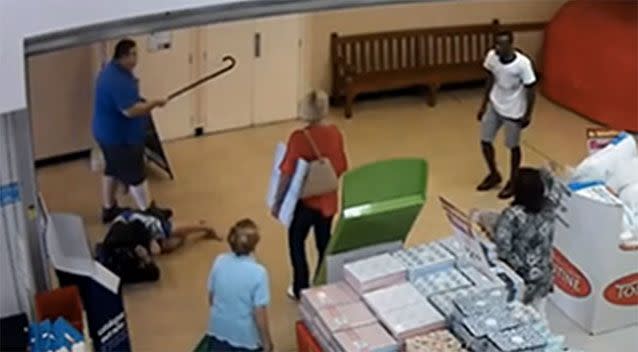 The man in the blue shirt fends off the attacker with his walking stick, forcing him out of the store. Picture: supplied