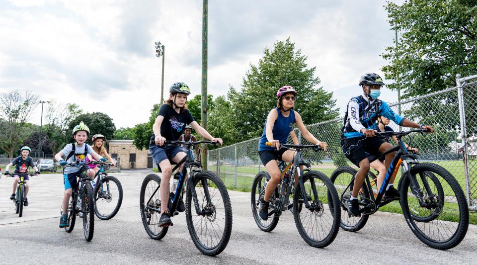 Milwaukee Mountain Bike students, including Riano Leyes (second from right) and Sydney Tezak (right), make their way to a nearby bike path on Thursday, July 21, 2022 at the MacDowell Community Center in Milwaukee.