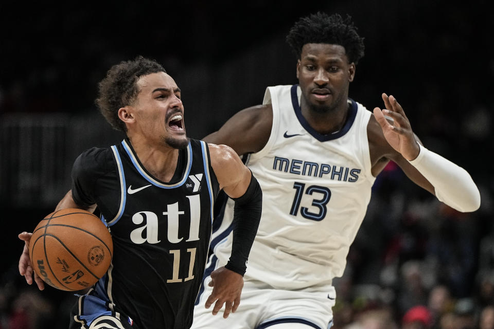 Atlanta Hawks guard Trae Young (11) moves against Memphis Grizzlies forward Jaren Jackson Jr. (13) during the second half of an NBA basketball game, Saturday, Dec. 23, 2023, in Atlanta. (AP Photo/Mike Stewart)