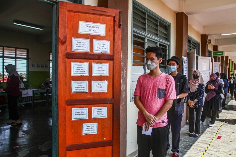 Voters line up to cast their ballot at the SK Ismail 1 polling station in Muar, Johor March 12, 2022.