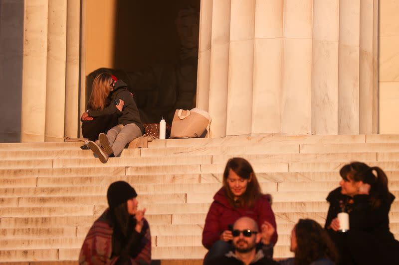 A couple embrace as a few people take to the steps at the Lincoln Memorial during the coronavirus disease (COVID-19) outbreak, where normally thousands of Christians would gather for worship at Easter sunrise, in Washington