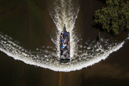 A military vehicle evacuates about two dozen residents from the Autumn Chase Park apartments while pushing its way through flood waters caused by Tropical Storm Harvey in Port Arthur, Texas, U.S. August 31, 2017. REUTERS/Adrees Latif