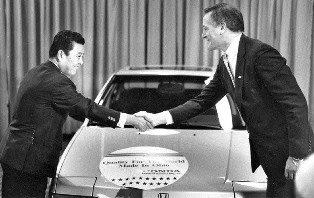 Tadashi Kume and Governor Richard F. Celeste shake hands during a 1987 press conference to announce new Honda plants in Ohio.
