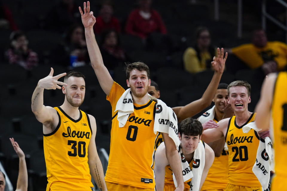 Iowa's Connor McCaffery (30), Filip Rebraca (0) and Payton Sandfort (20) celebrate on the bench in the second half of an NCAA college basketball game against Northwestern at the Big Ten Conference tournament in Indianapolis, Thursday, March 10, 2022. Iowa defeated Northwestern 112-76. (AP Photo/Michael Conroy)