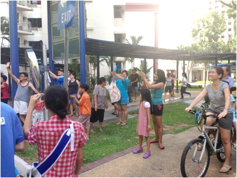 Punggol East residents claps and cars toot their horns as Workers' Party's parade convoy passes by.