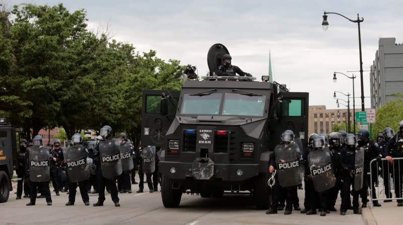 Detroit police, wearing riot gear, line up next to an armored vehicle in preparation to enforce a curfew following a rally against the death in Minneapolis police custody of George Floyd, in Detroit