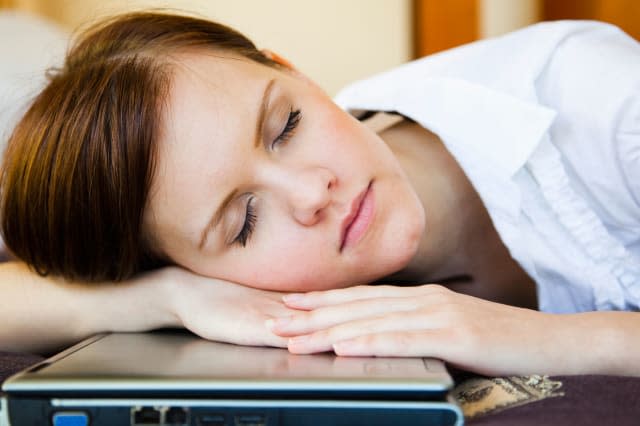 BKW7X3 Girl sleeping on computer