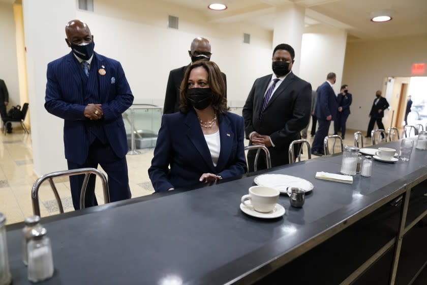 Vice President Kamala Harris sits at the lunch counter where four Black students sat down at Woolworth's lunch counter in Greensboro, N.C., and ordered coffee, during her visit to the International Civil Rights Center and Museum, Monday, April 19, 2021, in Greensboro, N.C. With Harris are Melvin Skip Alston-Guilford, County Board of Commissioners, Rev. Anthony Spearman and museum director John Swain. Harris is sitting in the same chair that Rosa Parks sat in during a visit in 1995. (AP Photo/Carolyn Kaster)