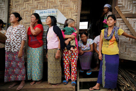 Women stand as Myanmar State Counselor Aung San Suu Kyi talks to people during a visit to an IDP camp outside Myitkyina, the capital city of Kachin state, Myanmar March 28, 2017. REUTERS/Soe Zeya Tun