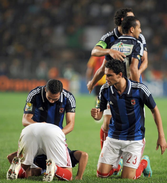 Egypt's Al-Ahly players pray after teammate, forward Nagi Ismail (bottom L), scores a goal against Esperance de Tunis during their CAF Confederation Cup match at Rades Olympic stadium near Tunis, on November 17, 2012. Ahly this year extended a record haul of CAF Champions League titles to seven